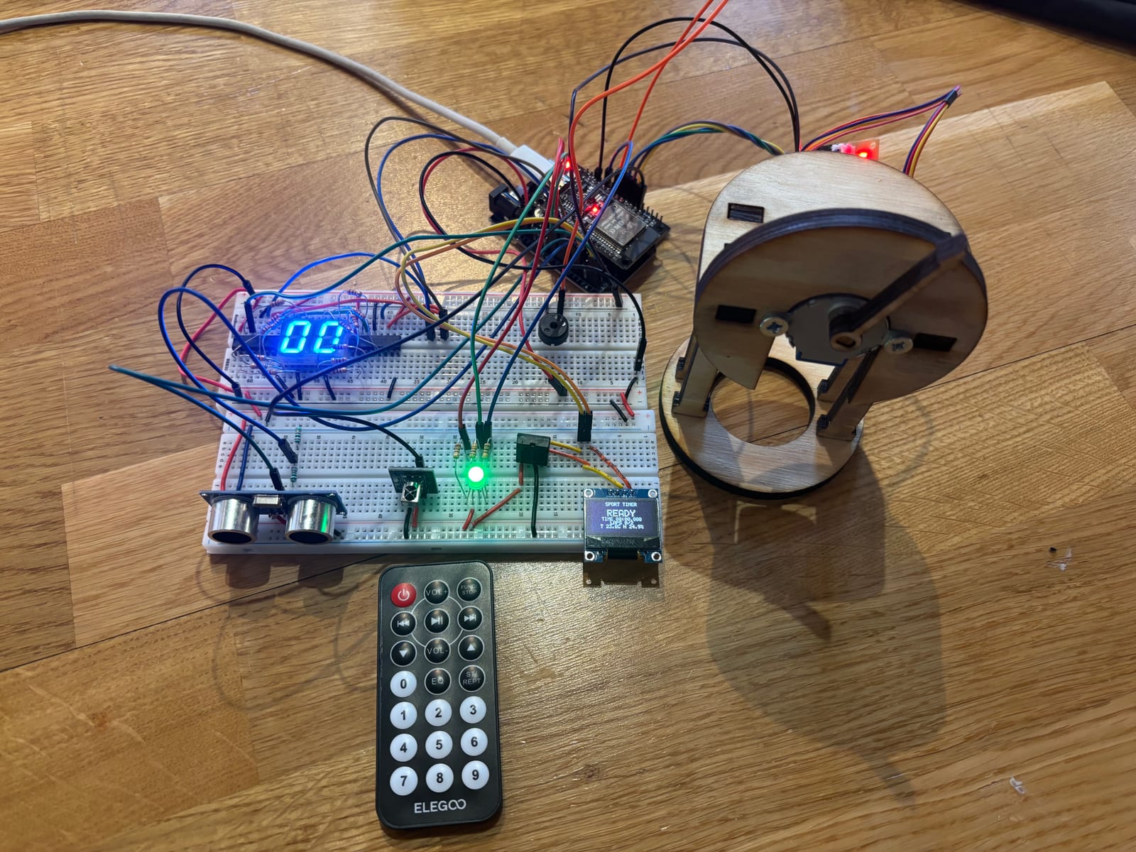 Breadboard prototype of the ESP32 sports timing system with displays, sensors, stepper motor, LED and wiring.